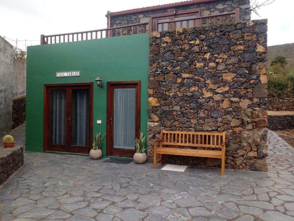 IsoraCasa Rural Casa Carlos的石墙建筑前的长凳