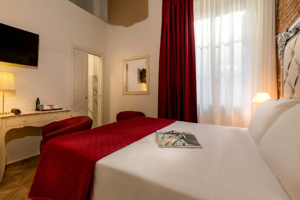 佛罗伦萨Residenza Conte di Cavour & Rooftop的酒店客房,配有一张带红色毯子的床