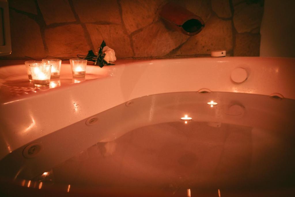 Castel Giuliano阿格里图丽斯莫特努塔蒙特拉瓜迪亚酒店的浴室内设有带蜡烛和玻璃的浴缸