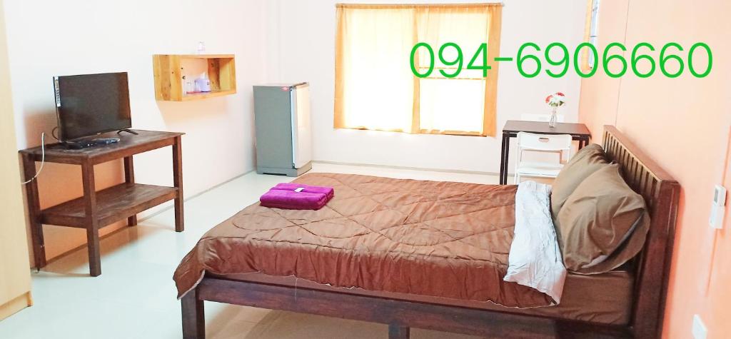 邦盛Banyan Resort Bangsaen的一间卧室,床上装有紫色手提箱