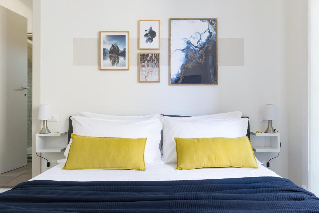 博洛尼亚Biasanòt Mini的一间卧室配有一张带黄色枕头的大床