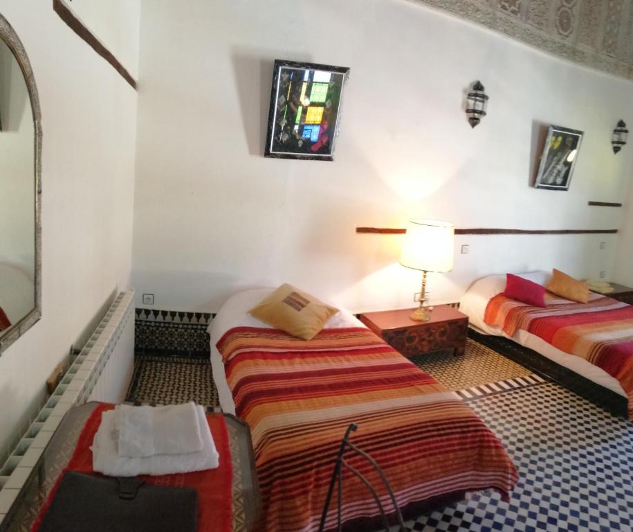 穆莱伊德里斯Dar Ines的酒店客房,设有两张床和一盏灯