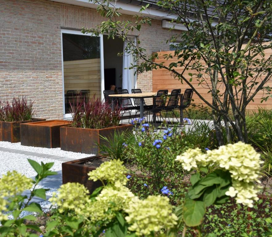 HammeVakantiewoning Lescaut的花园配有桌椅和鲜花