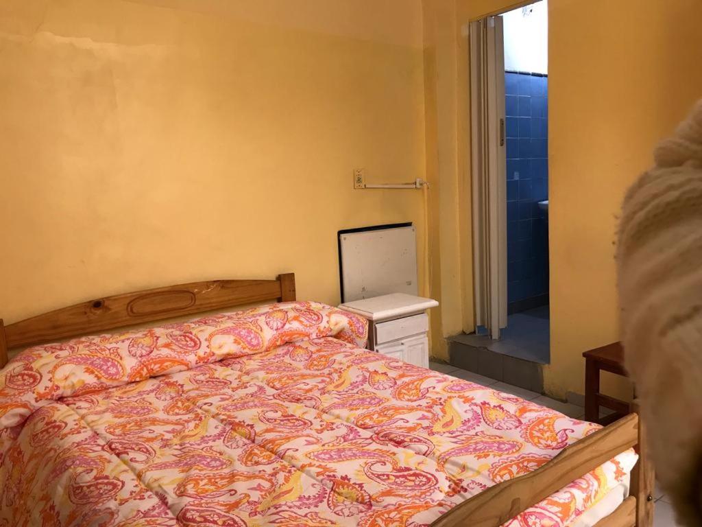 布宜诺斯艾利斯迈特套房旅馆的一间卧室配有一张床,一扇门通往浴室