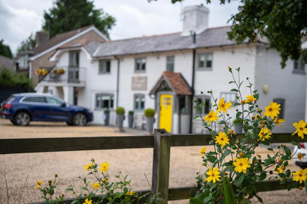 布罗肯赫斯特Cottage Lodge Hotel的前面有一辆蓝色汽车的房屋