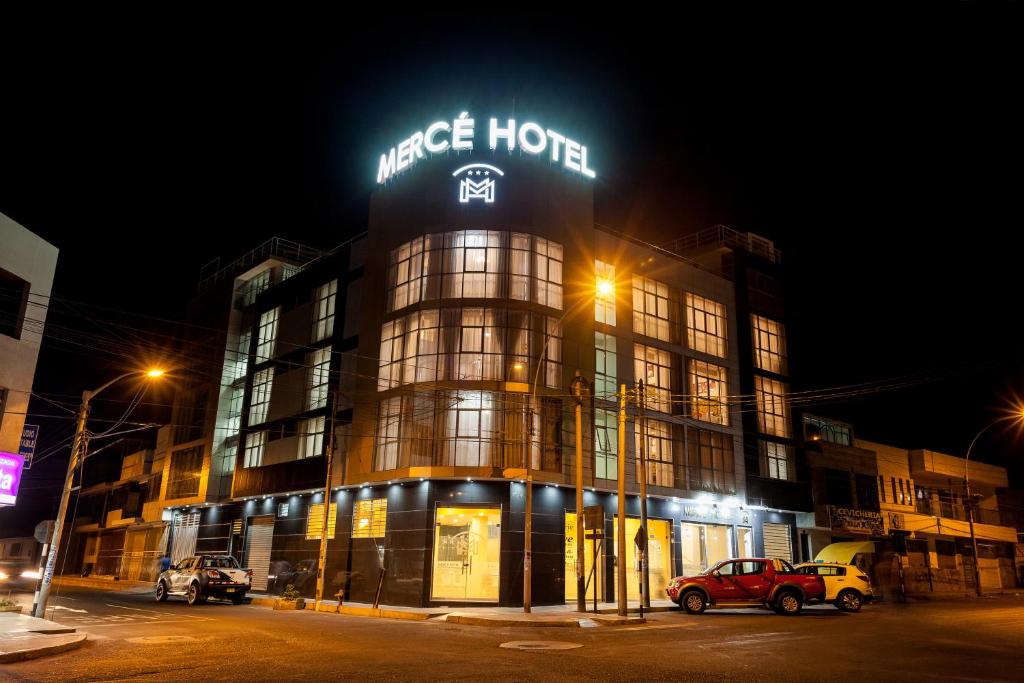 塔克纳Mercé Hotel的一座大建筑,晚上有标志