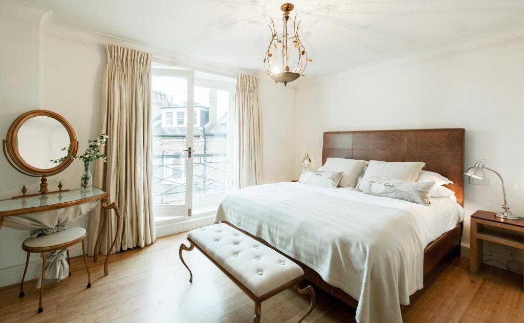 伦敦欧罗巴大楼公寓的一间卧室配有一张床、镜子和窗户