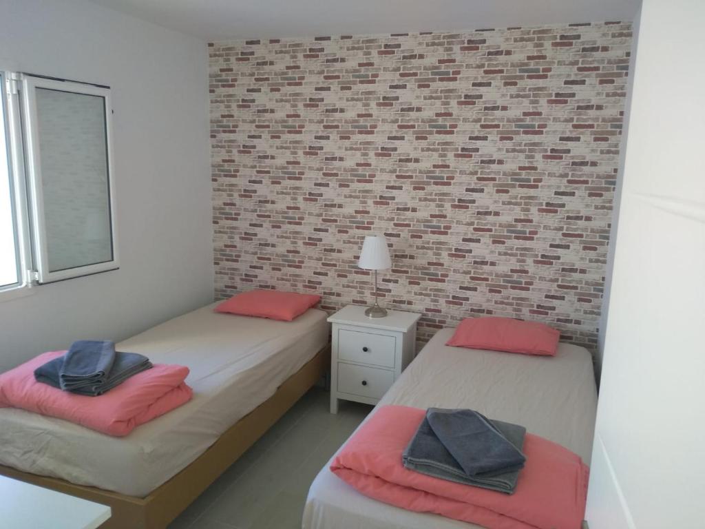 圣巴托洛梅Villa maravillosa的砖墙客房的两张床