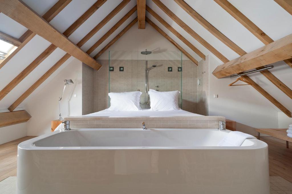 马斯特里赫特库尔8阁楼酒店的配有床的客房内的白色大浴缸