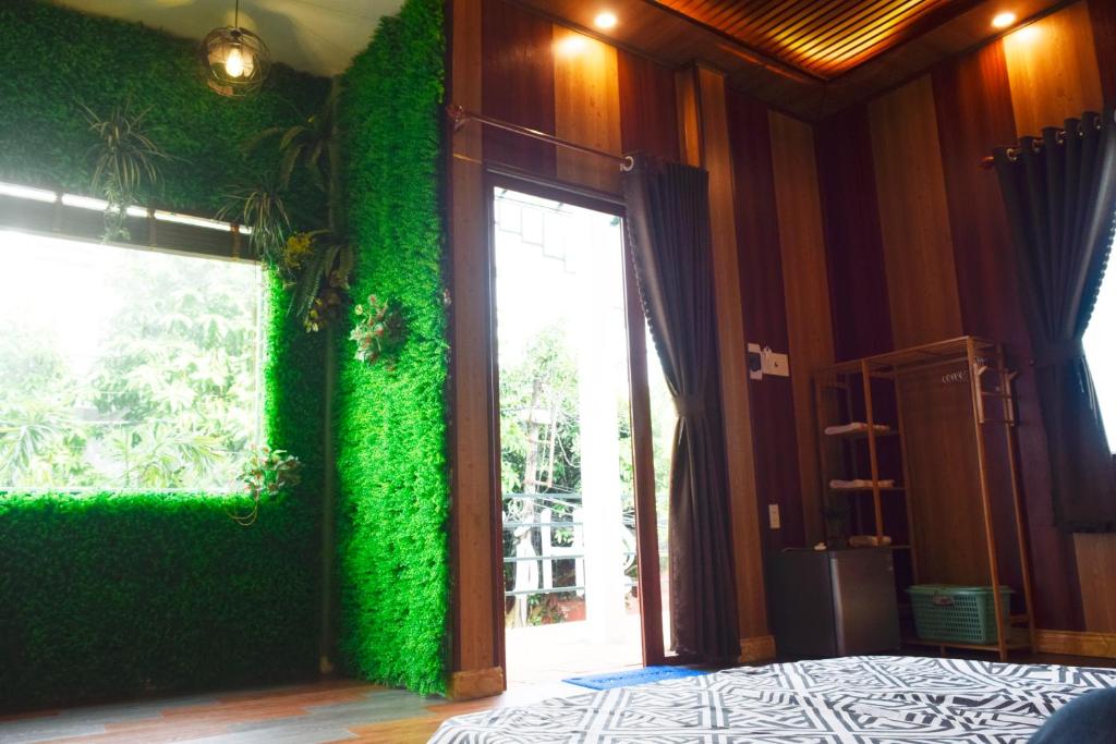 河仙Hà Tiên Homestay的一间设有绿色墙壁的客房,配有滑动玻璃门