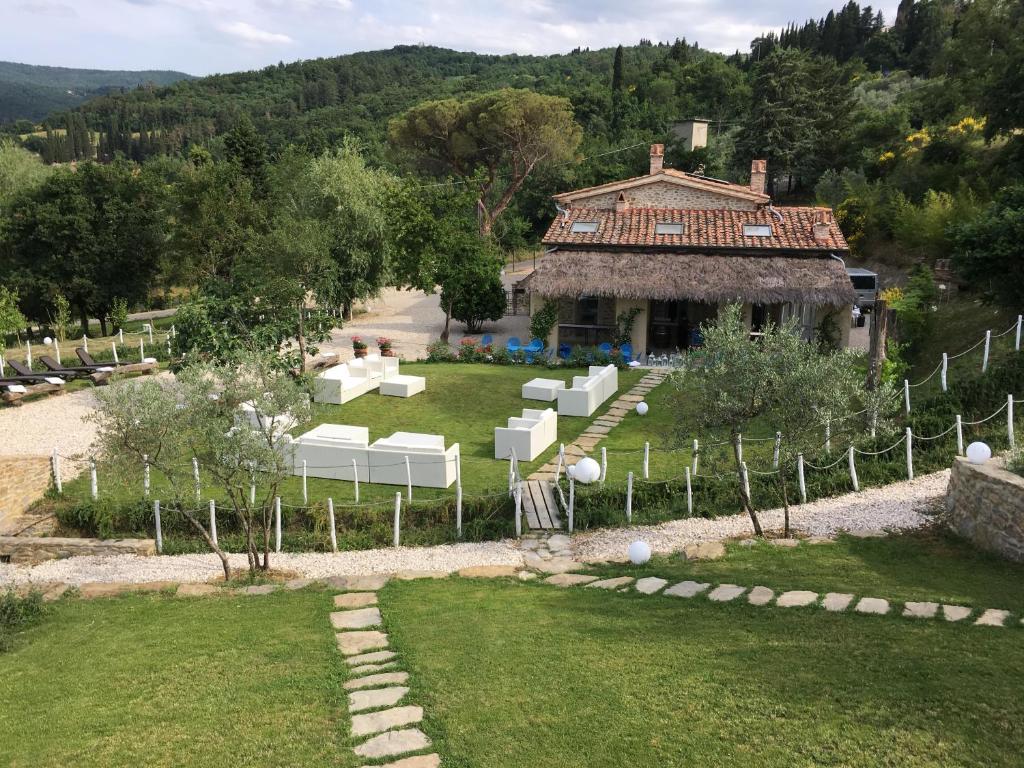 阿雷佐Podere Fontanino的一座带白色椅子的花园以及一座建筑