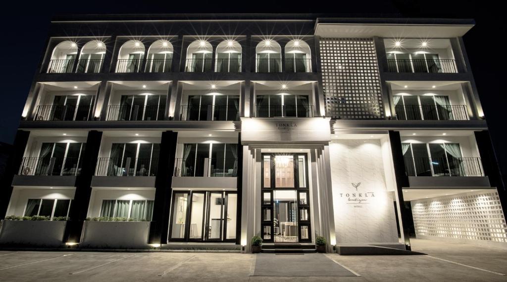 南奔Tonkla Boutique Hotel的一座建筑,在晚上有门在它前面