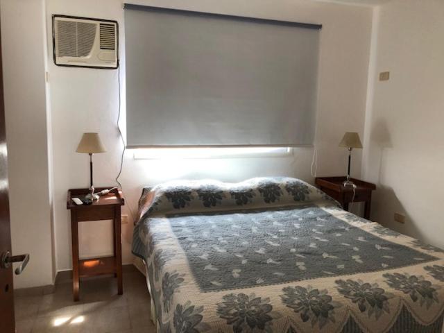 上格拉西亚Saint Michel Unidad Superior的一间卧室配有一张床和一个带风扇的窗户。