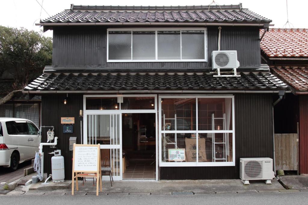 境港市Little Bird Inn 旧Minato Guesthouse的前面有标志的黑色建筑