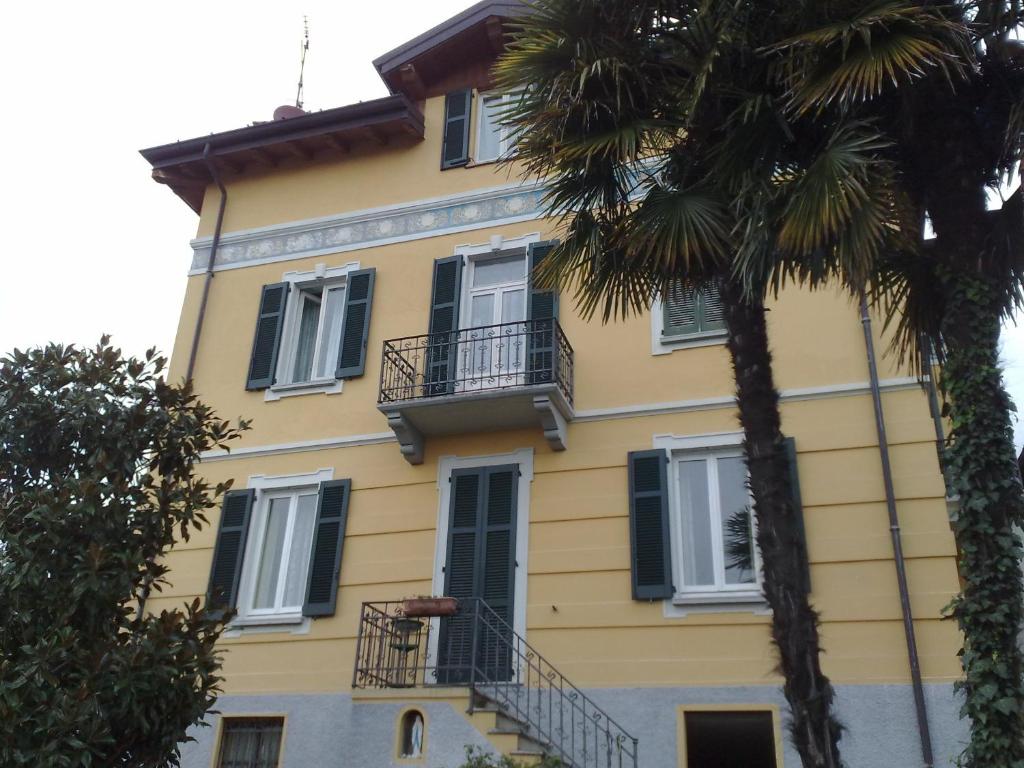 德尔维奥斯蒂夫别墅旅馆的黄色的建筑,有黑色的窗户和棕榈树