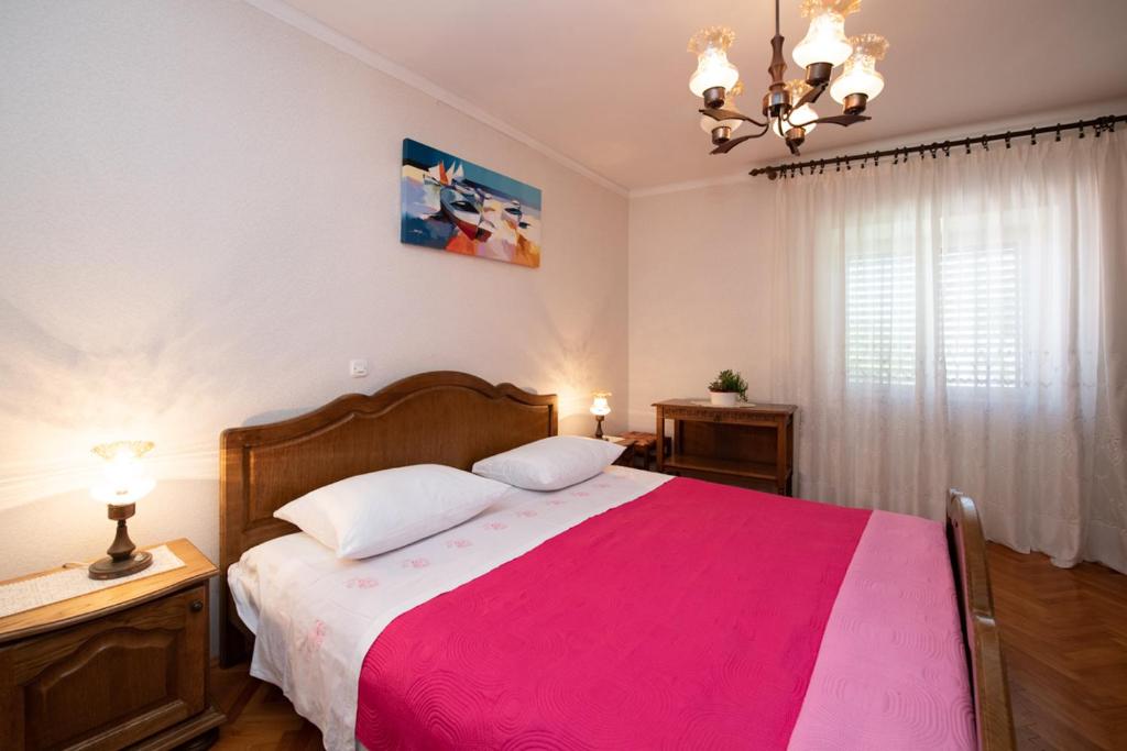 莫什尼卡德拉加Vacation home, Ferienhaus KLAUDIA in Kraj, Mošćenička Draga near Opatija的一间卧室配有一张带粉色毯子的大床