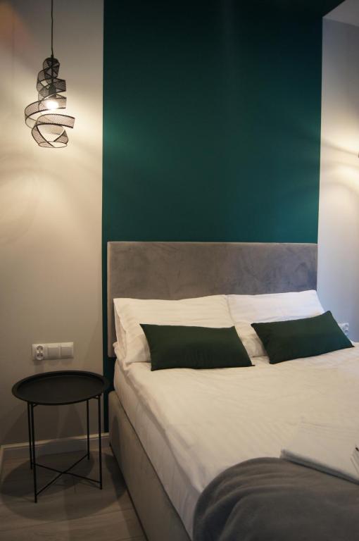 托伦Green Park Apartament的一间卧室设有一张大床和绿色的墙壁