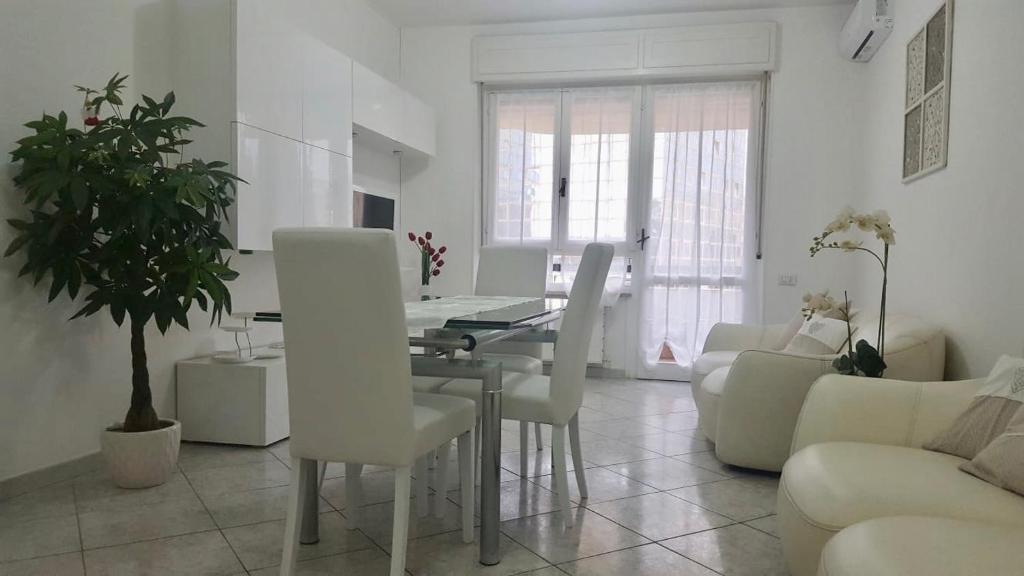 卡利亚里Elena’s home的客厅配有桌子和白色椅子
