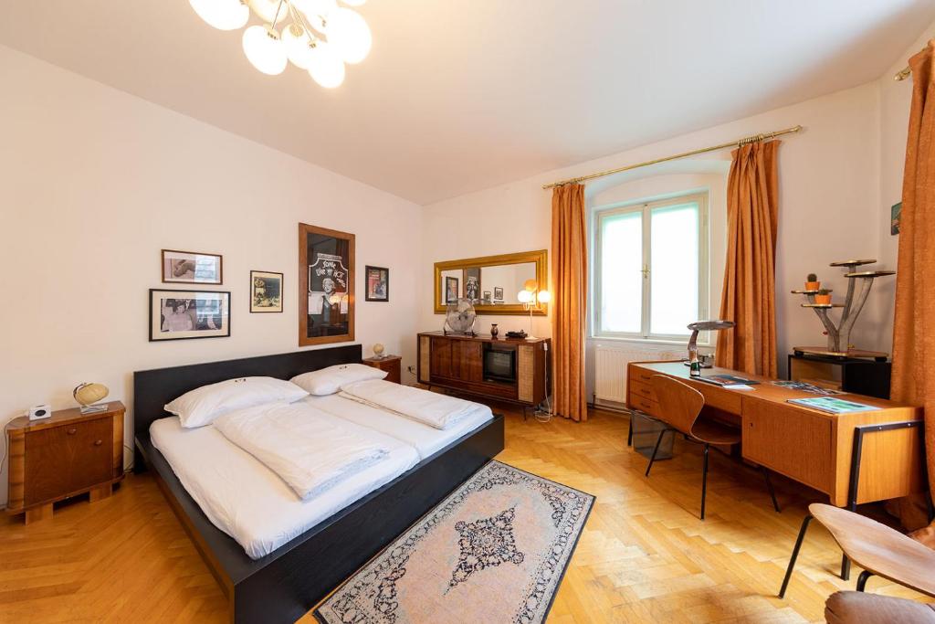 格拉茨六十年代公寓的一间卧室配有一张大床和一张书桌