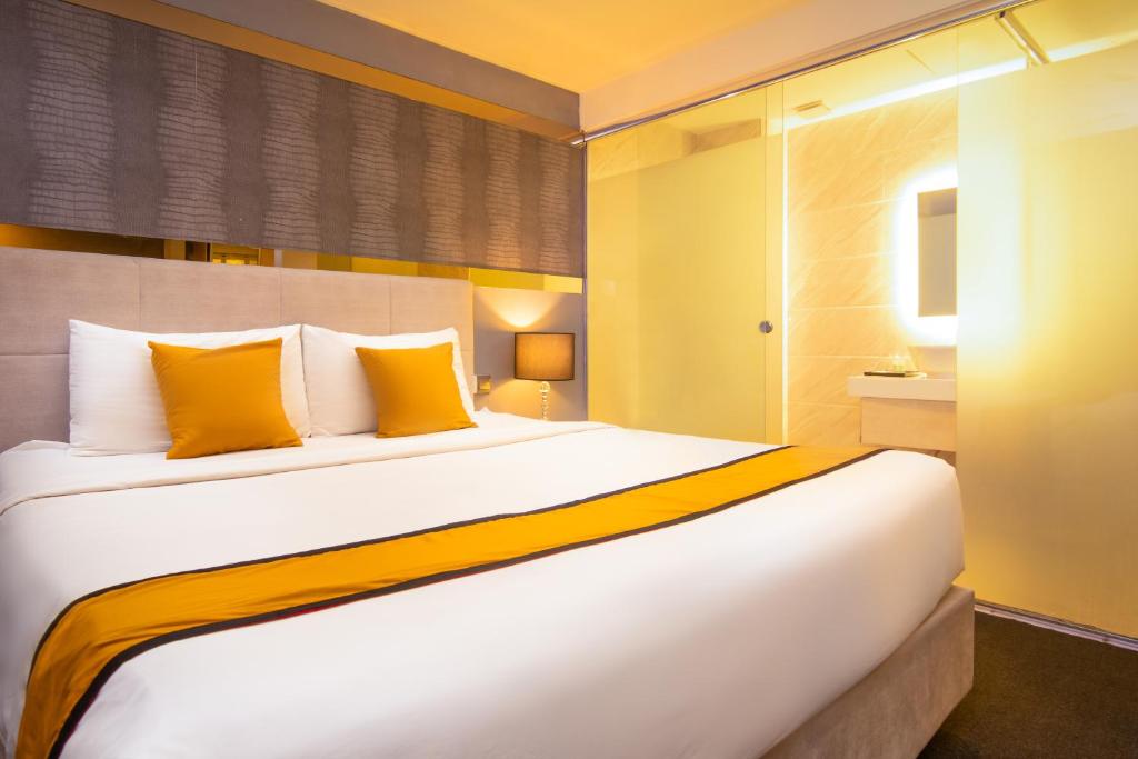 吉隆坡Royce Hotel @ KL Sentral的卧室配有一张带黄色枕头的大型白色床。
