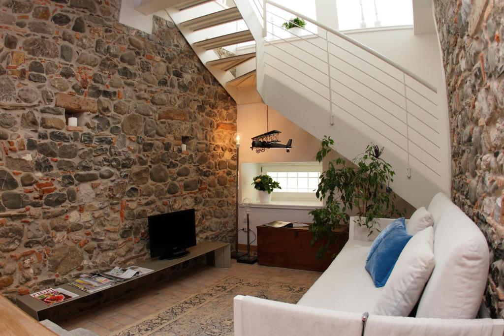 弗留利地区奇维达莱Casa Galante的客厅设有石墙和沙发。