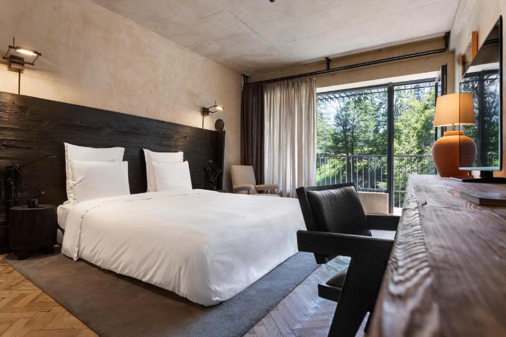 巴库里阿尼Rooms Hotel Kokhta的酒店客房设有一张大床和一张书桌。