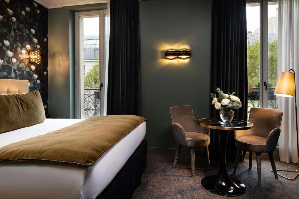 巴黎Rayz Eiffel的酒店客房,配有一张床和一张桌子及椅子