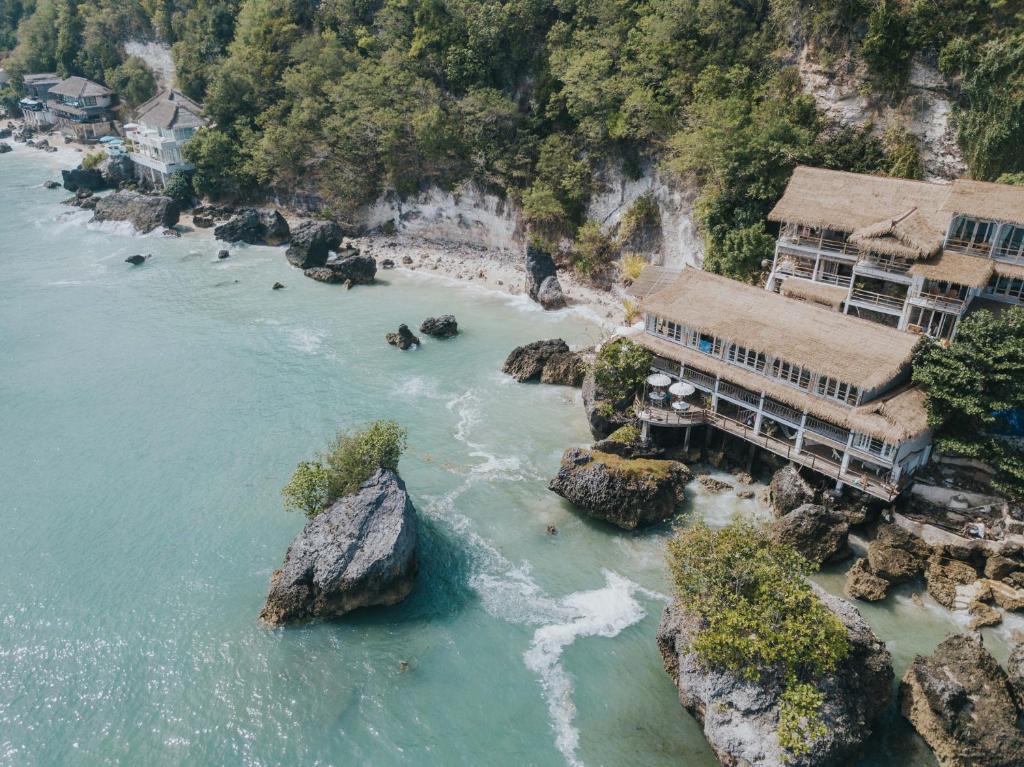 乌鲁瓦图德雷姆西巴厘度假村的享有河流的空中景色,设有房屋和岩石