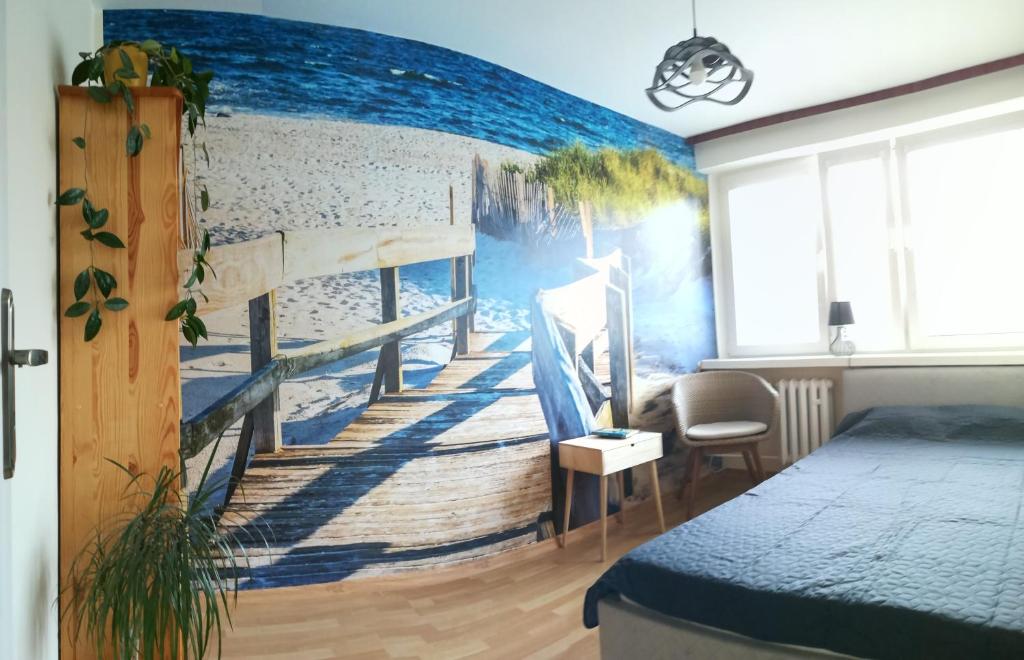 斯维诺乌伊希切Mieszkanie 2-pokojowe Świnoujście的一间卧室配有通往海滩的楼梯壁画