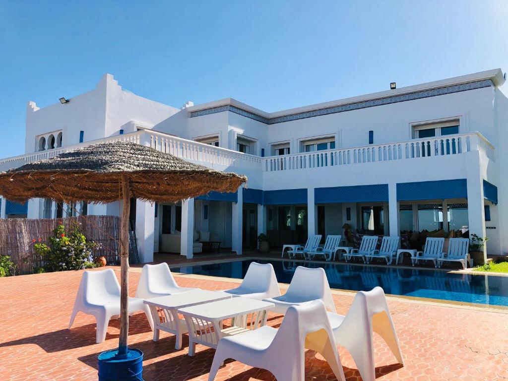 丹吉尔Villa Dar Jbila Tanger的别墅配有游泳池、椅子和遮阳伞
