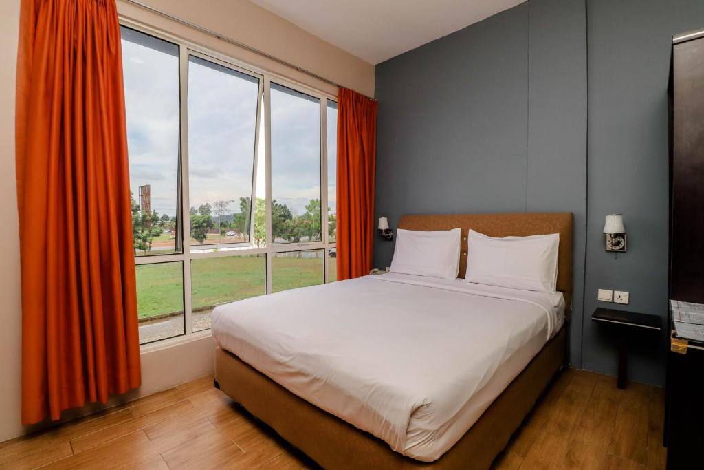 瑟古邦Blitz Hotel Batam Tanjung Uncang的一间卧室设有一张床和一个大窗户