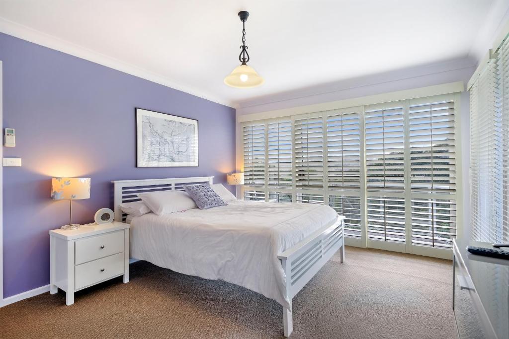 纽卡斯尔谷景住宿加早餐旅馆的卧室配有白色的床和紫色的墙壁