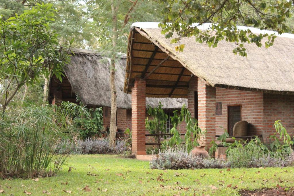 利隆圭Barefoot Lodge and Safaris - Malawi的庭院中带茅草屋顶的砖房