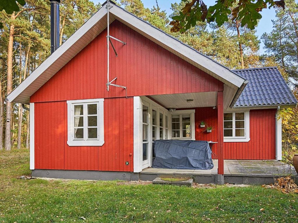维斯特索马肯6 person holiday home in Aakirkeby的红色的棚子,有白色的门和窗户