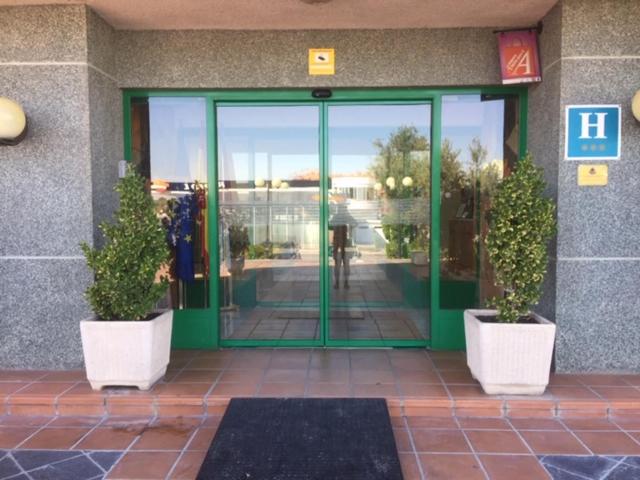 阿苏克卡德埃纳雷斯米拉尔坎波酒店的前面有两株盆栽植物的建筑物入口