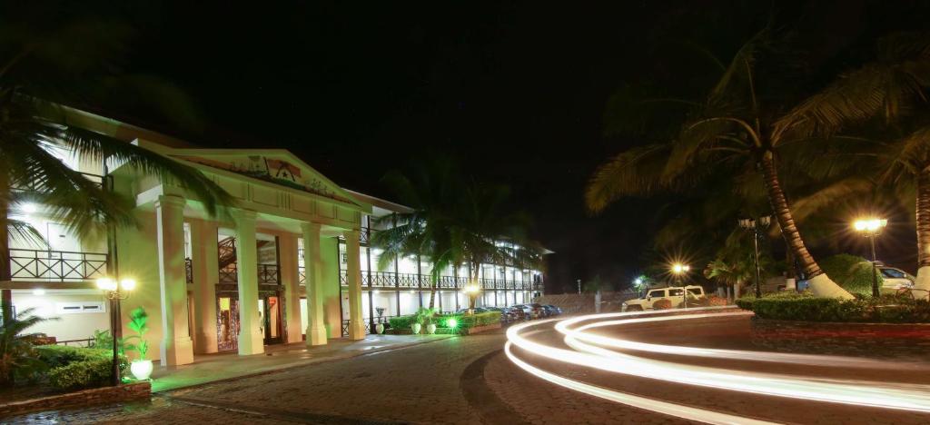 TeshiBest Western Plus Accra Beach Hotel的棕榈树和建筑的夜街