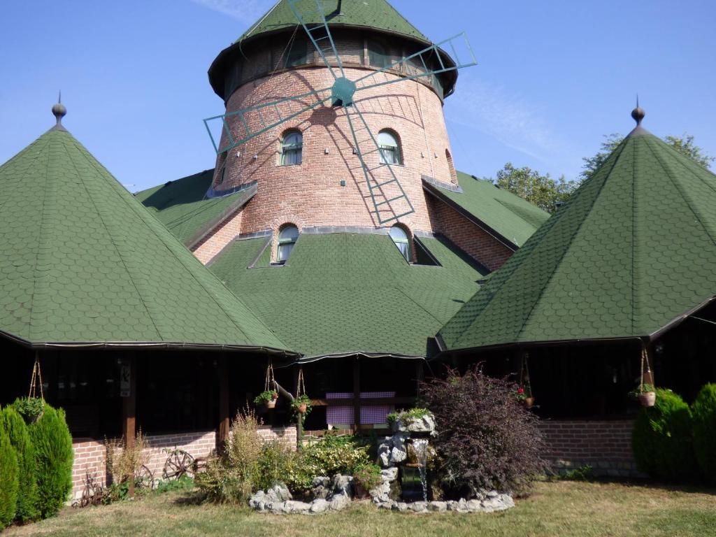 弗尔沙茨Hotel Vetrenjača的一座带绿屋顶和塔楼的建筑