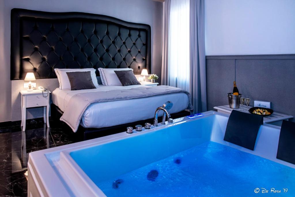 那不勒斯Villa Elisio Hotel & Spa的酒店客房设有一张床和一个配有床的浴缸。