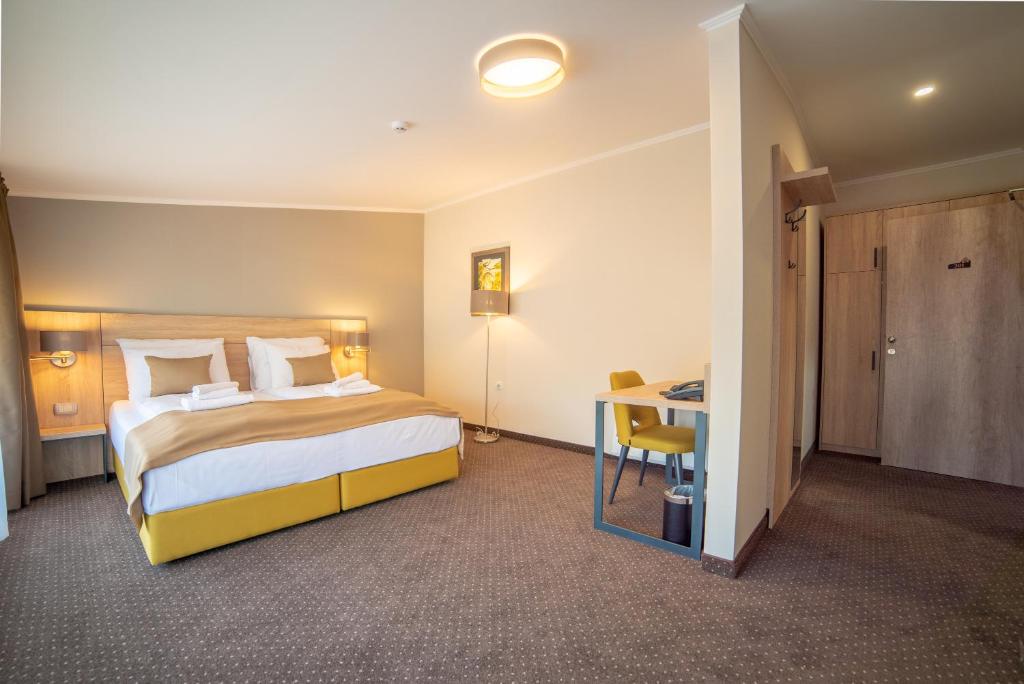 图兹拉Hotel Soni Lux的配有一张床和一张书桌的酒店客房