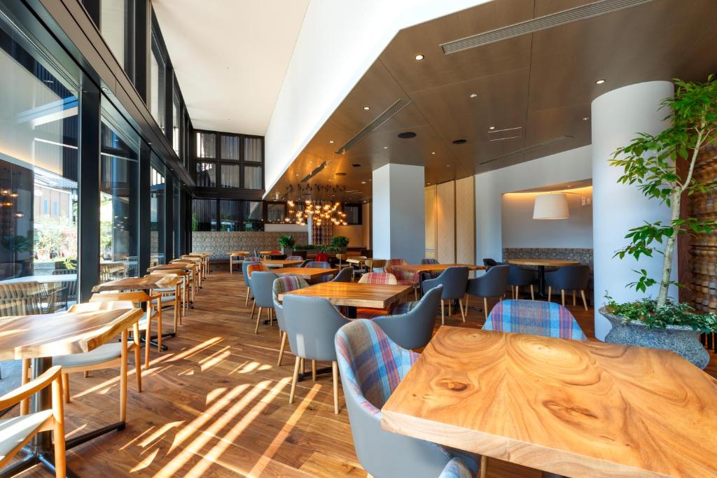 金泽Hotel Forza Kanazawa的配有木桌和椅子的餐厅