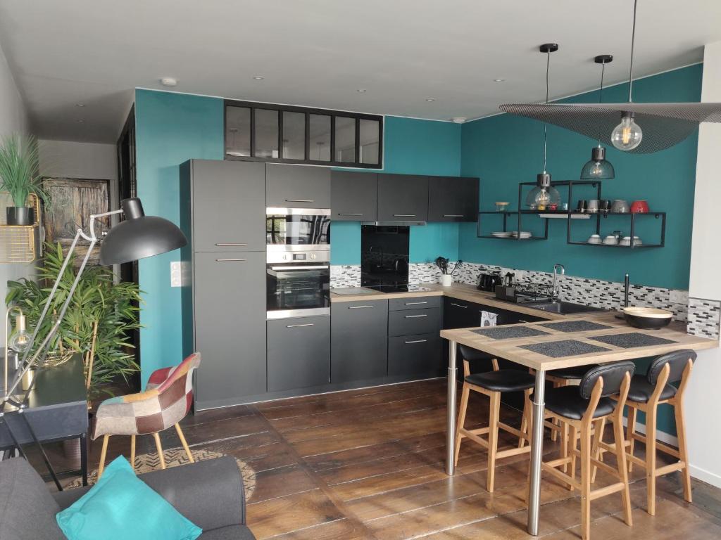 巴约讷Appmt Cosy 2 pièces - Haut Standing的厨房拥有蓝色的墙壁,配有桌椅