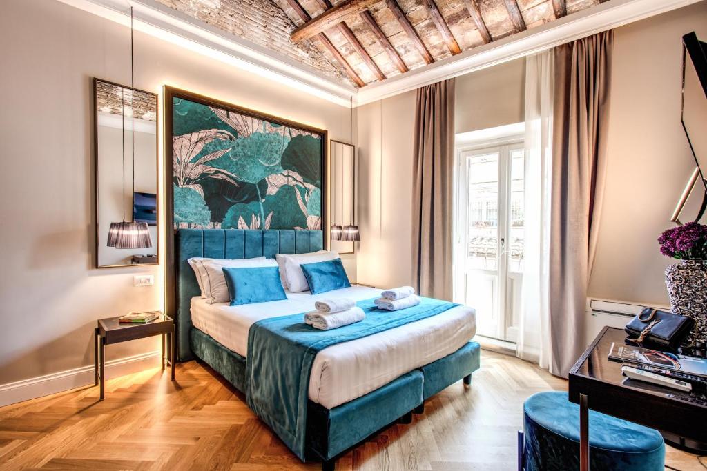 罗马Hotel 55 Fifty-Five - Maison d'Art Collection的卧室配有一张床,墙上挂有绘画作品