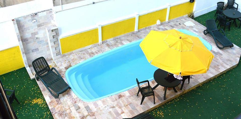 里约热内卢Arena Maracanã Hostel的享有带遮阳伞和椅子的游泳池的顶部景致