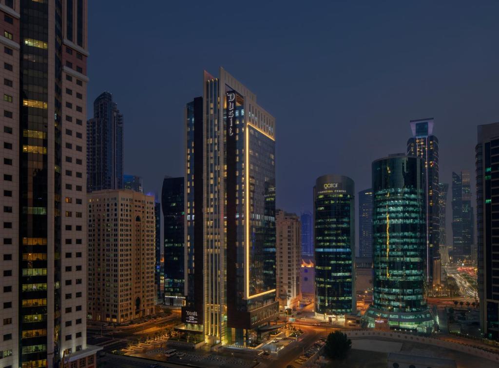 多哈Dusit Doha Hotel的城市天际线,晚上有高楼