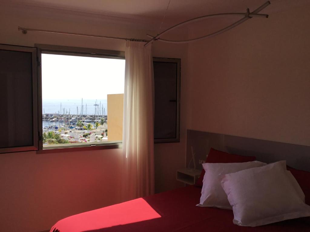 莫甘海滩Sunset Puerto de Mogan的一间卧室设有一张大床和大窗户