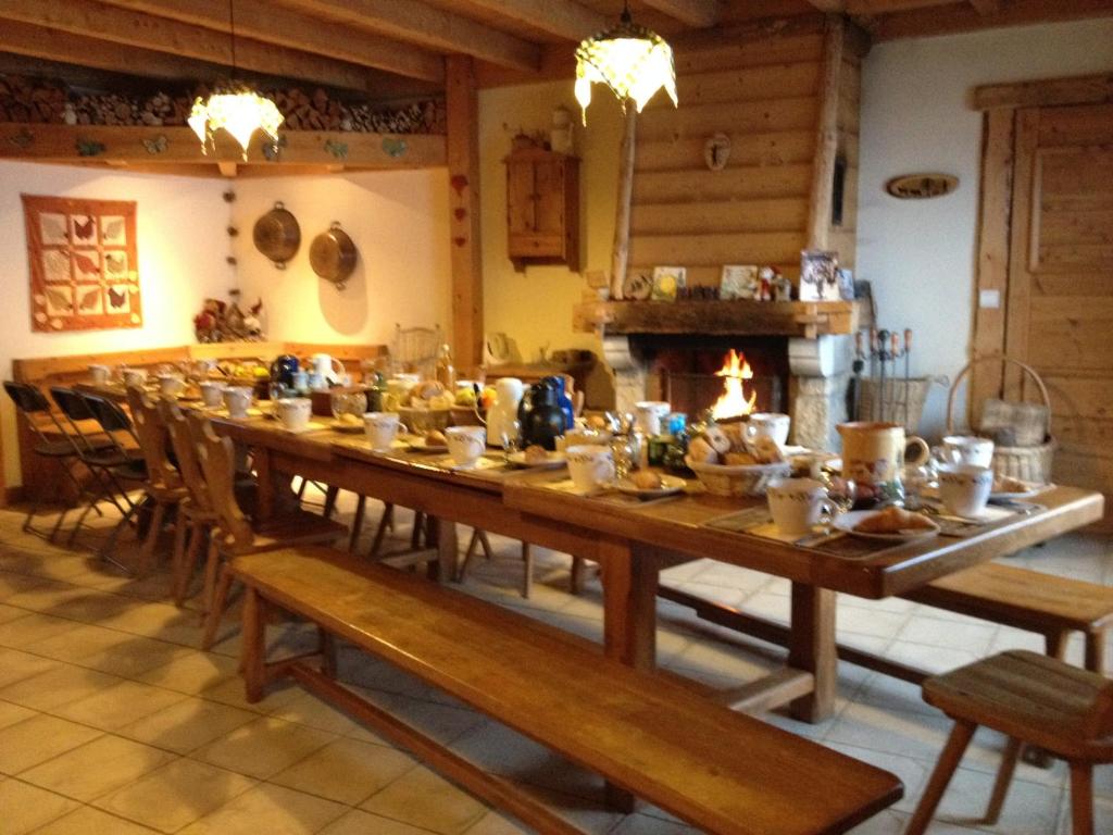 La MagneLes Pralets Plus的带壁炉的客房内的一张长木桌
