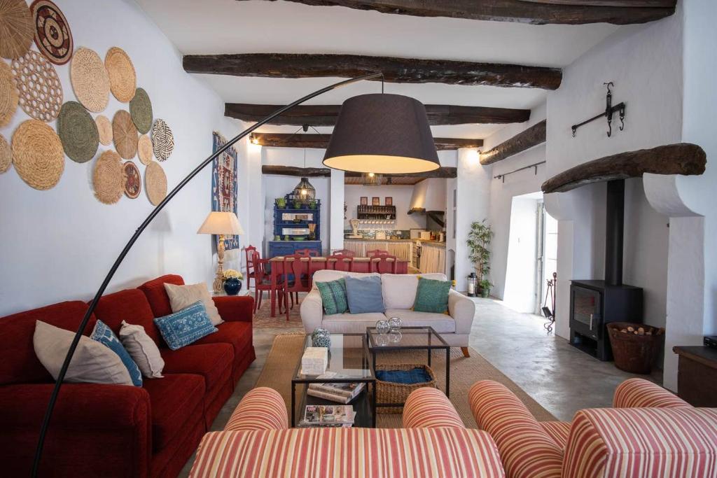 AlfeiriaCasa do Chafariz - House by the vines的客厅设有红色的沙发和壁炉