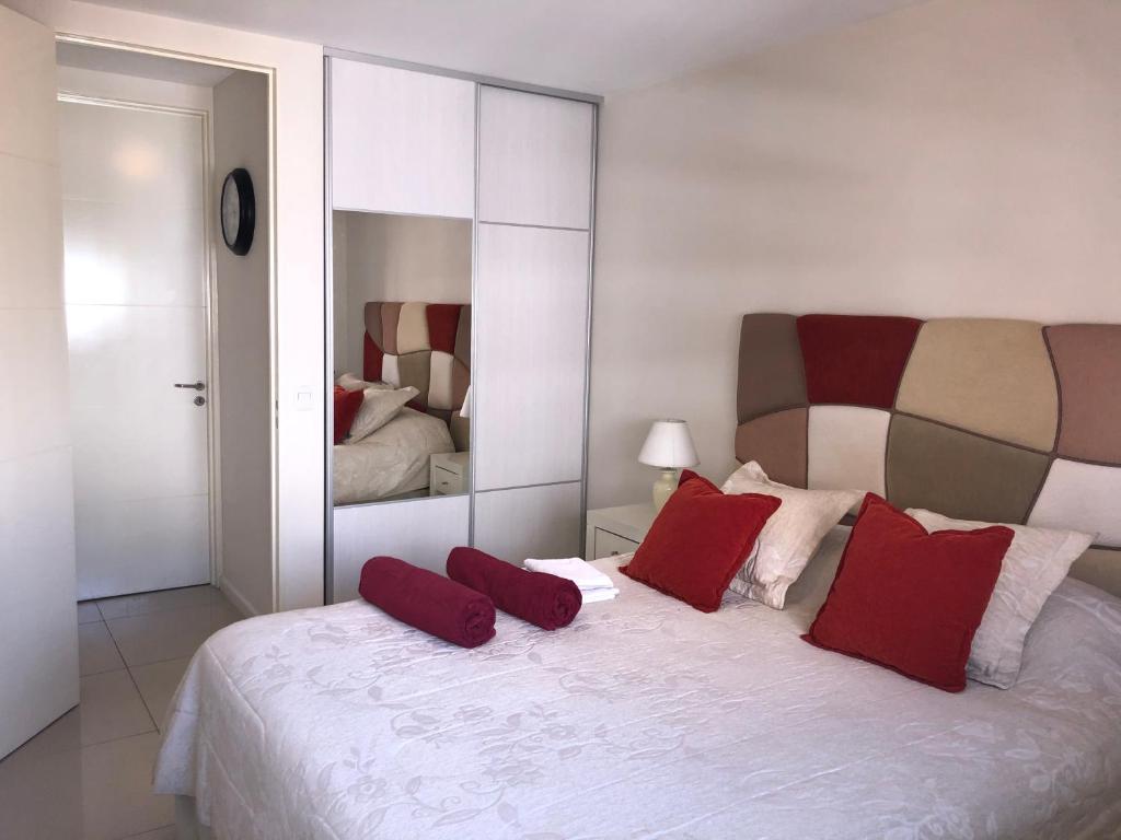 科尔多瓦Departamento boutique en nueva cordoba的卧室配有带红色枕头的大型白色床