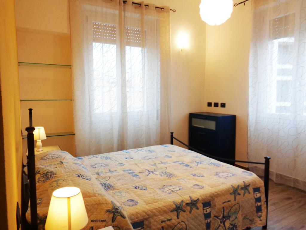 卡利亚里Wonderful apartment in Cagliari center的一间卧室配有一张床、一盏灯和两个窗户