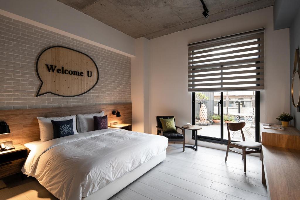 Tianzhong田中文旅的卧室配有白色的床和砖墙
